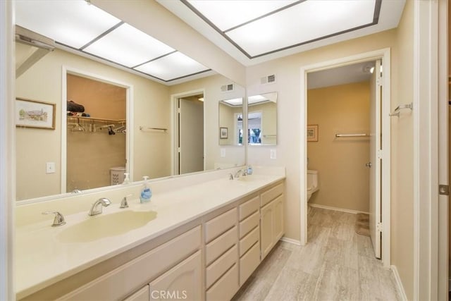 1692 Fairway Cir, Palm Springs, CA 92264 - full bathroom featuring double vanity, wood finished floors, visible vents, toilet, and a sink