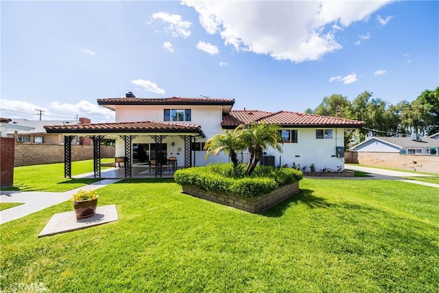 back of house with a tiled roof, a patio area, stucco siding, and a yard