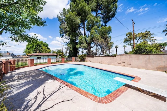 view of swimming pool with a diving board, a fenced backyard, a fenced in pool, and a patio area