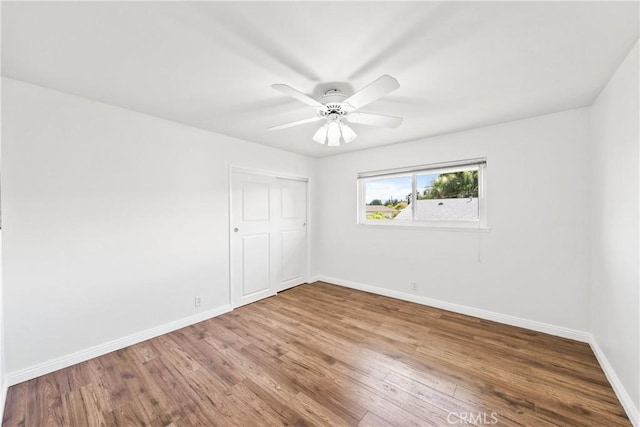 unfurnished room featuring baseboards, a ceiling fan, and wood finished floors