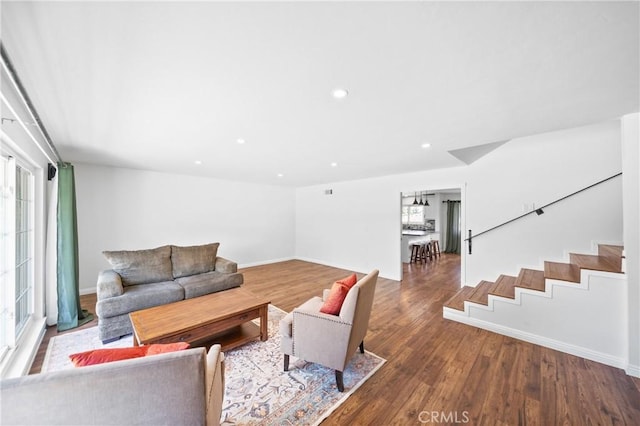living room featuring wood finished floors, recessed lighting, baseboards, and stairway
