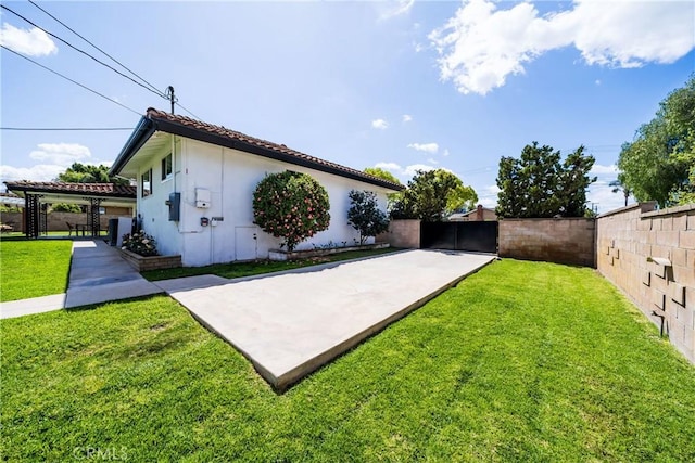 exterior space with a yard, fence, and stucco siding