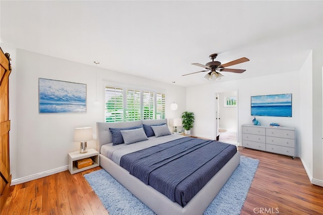 bedroom with baseboards, ceiling fan, and wood finished floors