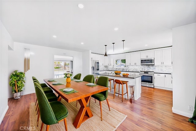 dining area featuring baseboards, recessed lighting, and light wood-style floors