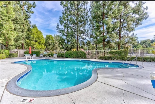 pool with fence and a patio