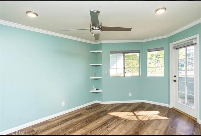unfurnished room featuring ornamental molding, baseboards, a healthy amount of sunlight, and wood finished floors