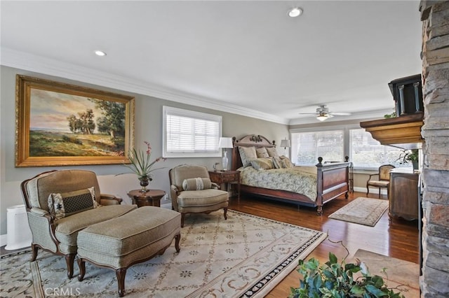 bedroom featuring wood finished floors, ornamental molding, baseboards, and multiple windows