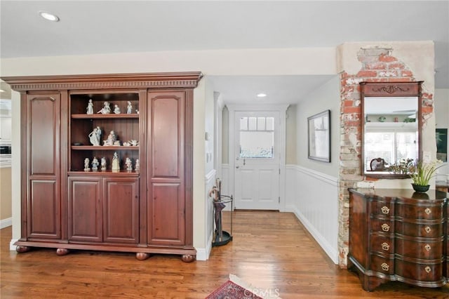 interior space featuring recessed lighting, a wainscoted wall, and wood finished floors
