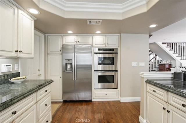 kitchen with a raised ceiling, appliances with stainless steel finishes, visible vents, and recessed lighting