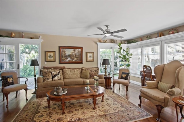 living room with wood finished floors, baseboards, and a ceiling fan