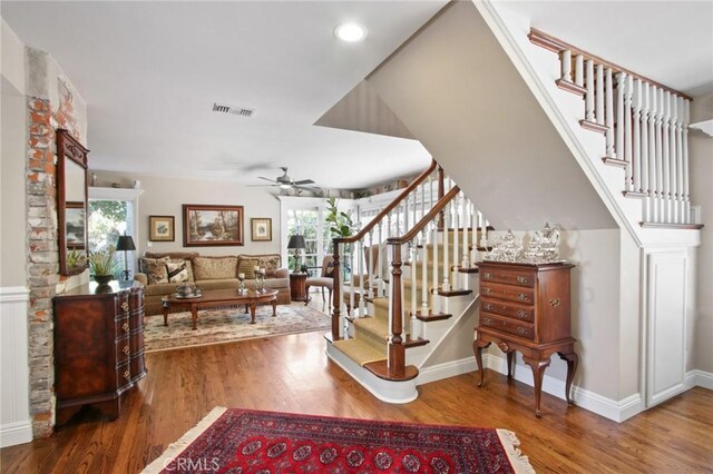 stairs featuring visible vents, baseboards, a ceiling fan, and wood finished floors
