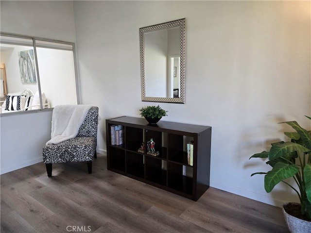 living area featuring baseboards and wood finished floors