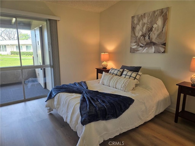 bedroom featuring access to outside and wood finished floors