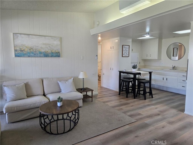 living room featuring light wood-style floors and a ceiling fan