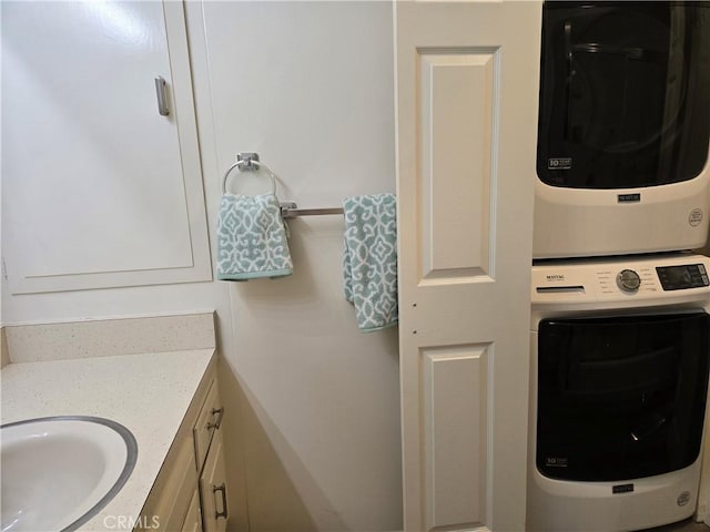laundry room with a sink, stacked washer / dryer, and laundry area