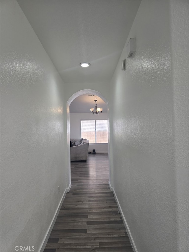 37623 Teal St, Palmdale, CA 93552 - corridor featuring a chandelier, arched walkways, baseboards, wood finished floors, and a textured wall