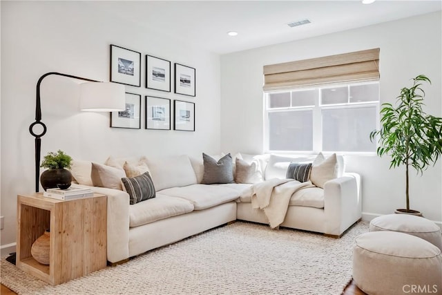 living area featuring recessed lighting, visible vents, and baseboards