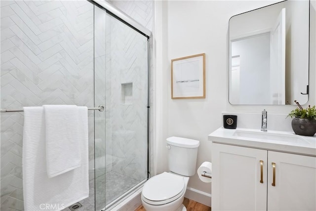 bathroom featuring a shower stall, vanity, and toilet