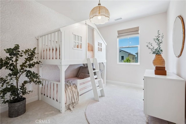 carpeted bedroom featuring visible vents, baseboards, and wallpapered walls