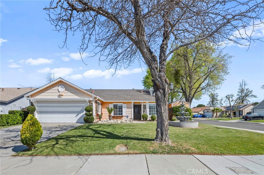 ranch-style house featuring a front lawn, an attached garage, and concrete driveway