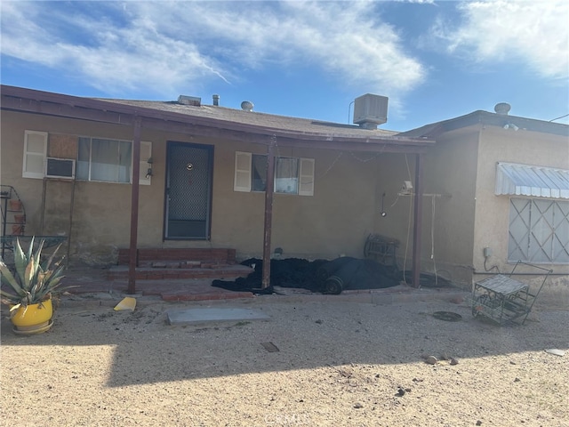 44531 Tioga St, Newberry Springs, CA 92365 - back of house with cooling unit, entry steps, and stucco siding