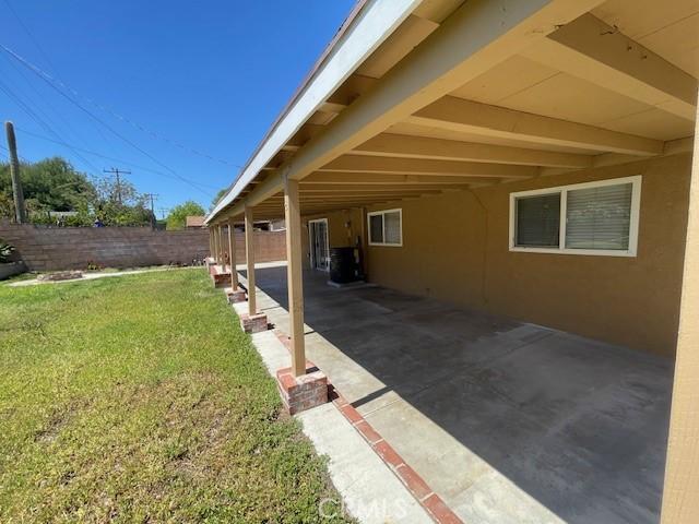 exterior space with a carport and fence