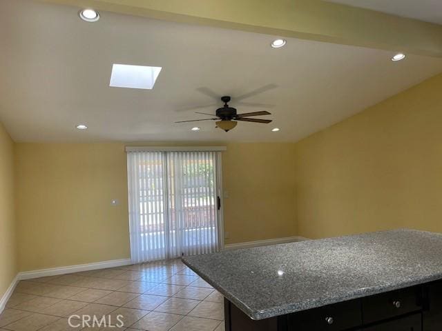interior space with baseboards, a ceiling fan, recessed lighting, a skylight, and light tile patterned flooring
