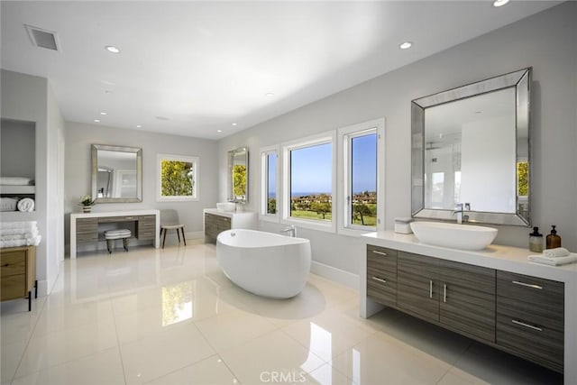 full bathroom with a freestanding tub, vanity, visible vents, and recessed lighting