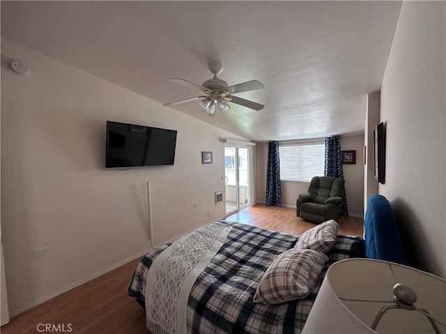 bedroom with lofted ceiling, ceiling fan, baseboards, and wood finished floors
