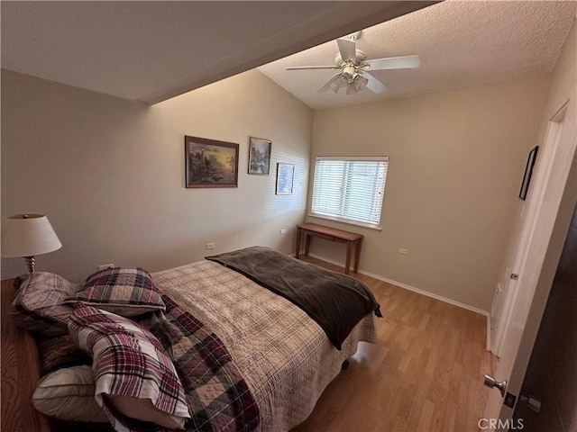 bedroom featuring baseboards, light wood finished floors, ceiling fan, and vaulted ceiling