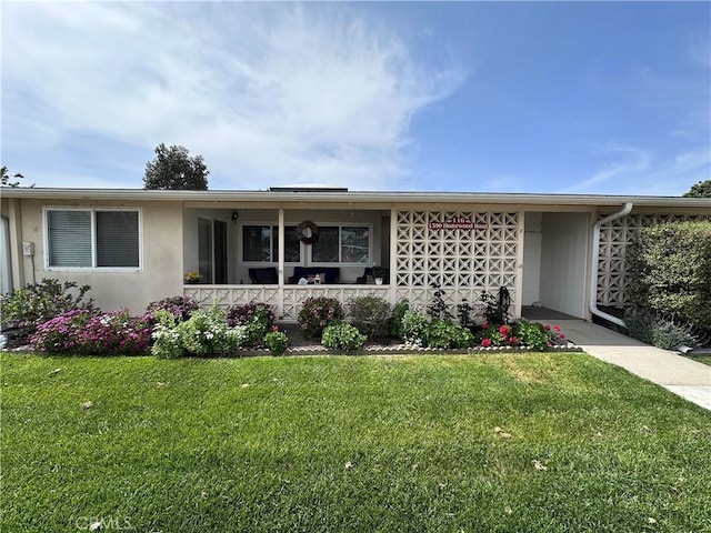 ranch-style home with a porch, stucco siding, and a front lawn