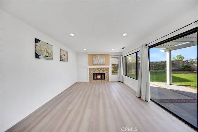 unfurnished living room featuring visible vents, baseboards, a tiled fireplace, and recessed lighting