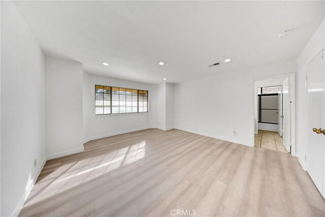 unfurnished room featuring light wood-type flooring, visible vents, and recessed lighting