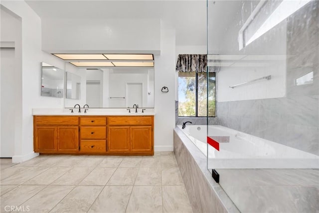 bathroom with a sink, tile patterned floors, double vanity, baseboards, and a bath