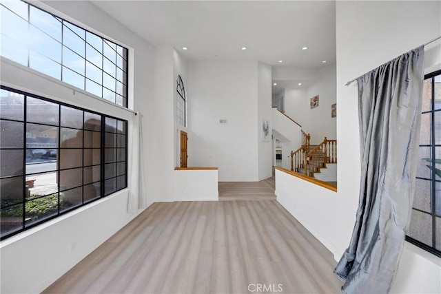 carpeted foyer with stairs, recessed lighting, and a towering ceiling