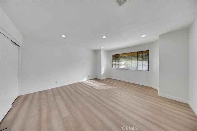 unfurnished room with light wood-type flooring, recessed lighting, baseboards, and visible vents