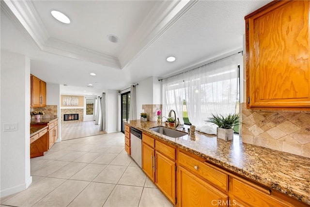 kitchen with a sink, brown cabinets, backsplash, and dishwasher