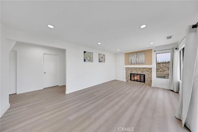 unfurnished living room featuring light wood-type flooring, visible vents, baseboards, and recessed lighting