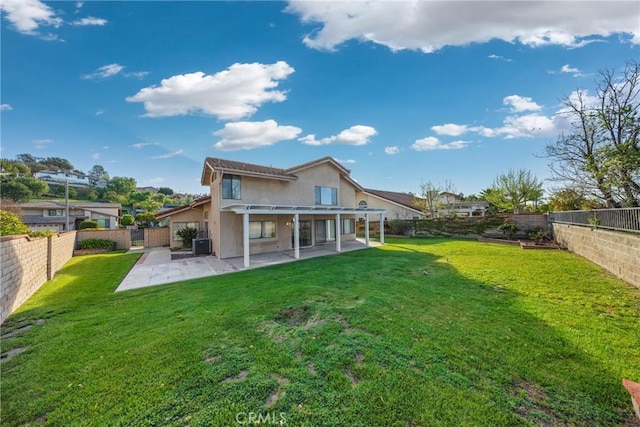 rear view of property featuring a fenced backyard, a patio area, stucco siding, and a yard