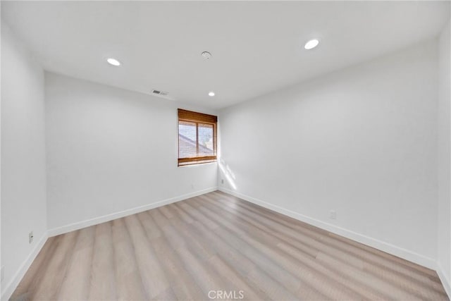 unfurnished room featuring light wood-type flooring, recessed lighting, baseboards, and visible vents