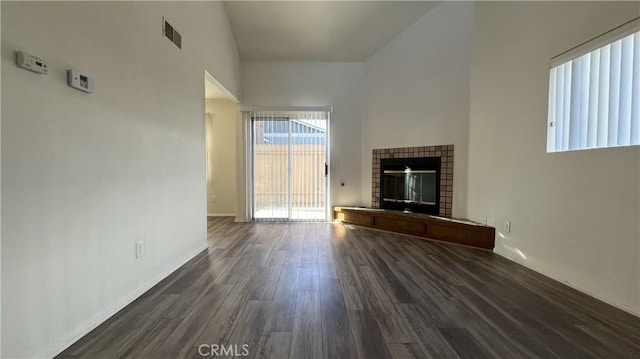 20211 Carlisle Rd, Apple Valley, CA 92307 - unfurnished living room featuring healthy amount of natural light, dark wood-style floors, a glass covered fireplace, and baseboards