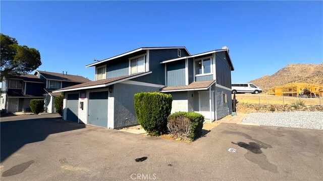20211 Carlisle Rd, Apple Valley, CA 92307 - traditional-style house with a mountain view, asphalt driveway, a garage, and a chimney