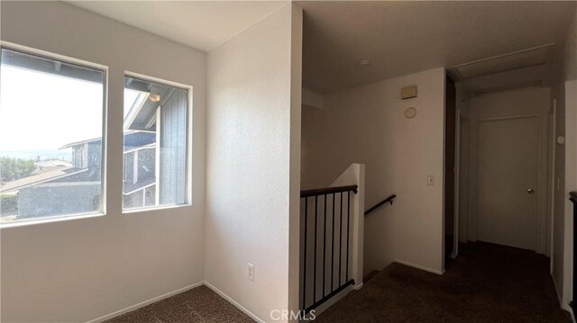 20211 Carlisle Rd, Apple Valley, CA 92307 - hallway featuring plenty of natural light, dark colored carpet, an upstairs landing, and baseboards