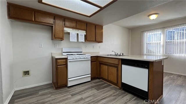 20211 Carlisle Rd, Apple Valley, CA 92307 - kitchen with white appliances, a sink, a peninsula, wood finished floors, and brown cabinets