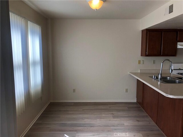 20211 Carlisle Rd, Apple Valley, CA 92307 - kitchen with a sink, light wood finished floors, light countertops, baseboards, and dark brown cabinets