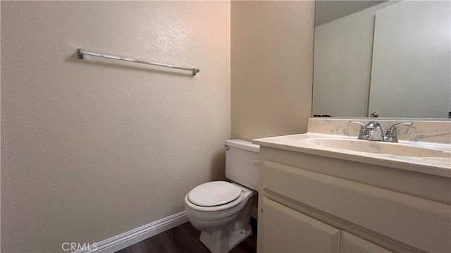 20211 Carlisle Rd, Apple Valley, CA 92307 - half bathroom with toilet, vanity, wood finished floors, and baseboards