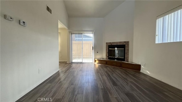 20211 Carlisle Rd, Apple Valley, CA 92307 - unfurnished living room featuring plenty of natural light, dark wood-type flooring, a tiled fireplace, and baseboards