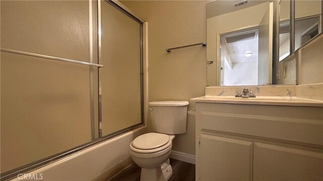 20211 Carlisle Rd, Apple Valley, CA 92307 - bathroom featuring toilet, vanity, combined bath / shower with glass door, baseboards, and wood finished floors