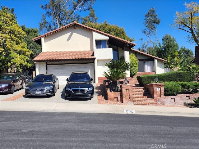 mediterranean / spanish home with stucco siding, concrete driveway, a garage, and a tile roof