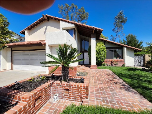 view of front facade with driveway, stucco siding, a tile roof, and a garage